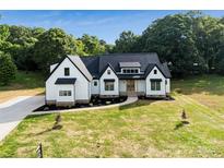 Beautiful modern farmhouse with black accents, a manicured lawn, and a private wooded backdrop at 5015 Lancaster Hwy, Monroe, NC 28112