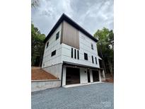 Modern two-story home showcasing white siding, dark window trim, and a two-car garage at 908 Apex Dr, Albemarle, NC 28001