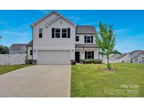 Charming two-story home featuring a well-manicured lawn and attached two-car garage at 1315 Elizabeth Ave, Kannapolis, NC 28083
