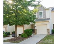 Charming two-story townhome featuring a one-car garage, manicured lawn, and inviting front entrance at 14411 Glendon Hall Ln, Charlotte, NC 28262