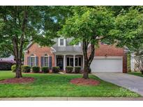 Charming brick home featuring a well-manicured lawn and mature trees in a desirable neighborhood at 16013 Wynfield Creek Pkwy, Huntersville, NC 28078
