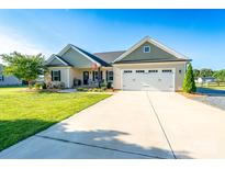 Charming single-story home with a manicured lawn, a two-car garage, and a welcoming front porch at 17438 Purser Dr, Locust, NC 28097
