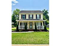 Charming two-story home featuring a covered front porch and well-manicured landscaping at 1912 Baxter St, Charlotte, NC 28204