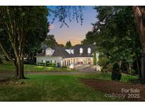 Beautiful brick home featuring mature trees, manicured lawn, and inviting front entrance at 19506 Mary Ardrey Cir, Cornelius, NC 28031