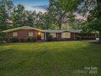 Charming brick home with a well-manicured lawn and mature trees, offering a serene and inviting curb appeal at 2831 Puetts Chapel Rd, Bessemer City, NC 28016