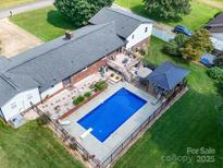Aerial view of a fenced swimming pool, gazebo, and deck in a lush green backyard at 3509 Flint Dr, Statesville, NC 28677