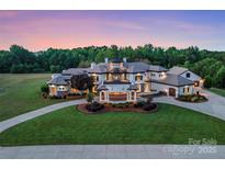 Stunning luxury home featuring manicured lawn, circular driveway, and impeccable landscaping at 355 Pelham Ln, Mooresville, NC 28115