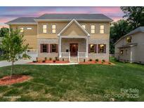 Charming two-story home featuring a brick and siding exterior, covered front porch, and well-manicured lawn at 4015 Randolph Rd, Charlotte, NC 28211