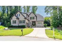 Charming brick two-story home with manicured lawn and mature trees, featuring a long driveway and welcoming front porch at 4017 Halyard Dr, Denver, NC 28037