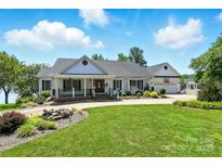 Charming single-story home featuring a well-manicured lawn, inviting front porch, and an attached two-car garage at 441 Wildlife Club Ln, Taylorsville, NC 28681