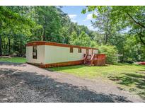 Charming single-story home with gravel driveway and a small deck at 5239 Lineberger Rd, Stanley, NC 28164