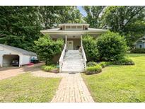 Charming home with a welcoming front porch, complemented by lush greenery at 816 Fulton St, Albemarle, NC 28001