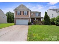 Charming two-story home with a manicured lawn, stone accents, and an attached two-car garage at 8915 Merrie Rose Ave, Charlotte, NC 28213