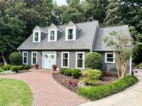 Charming home featuring a brick pathway, manicured landscaping, and a light blue front door with decorative wreaths at 9305 Harps Mill Ct, Charlotte, NC 28270
