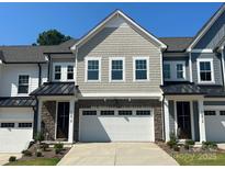 Charming townhome featuring stone accents, a two-car garage, and professionally landscaped front yard at 10416 Audubon Ridge Dr # 4, Cornelius, NC 28031