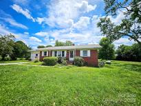 Charming single-story brick home featuring a well-manicured lawn and inviting front porch at 1050 Old Peachland Rd, Marshville, NC 28103