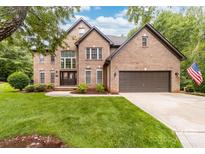 Beautiful brick two-story home with an attached two-car garage and well-manicured front lawn at 12002 Cobham Ct, Huntersville, NC 28078