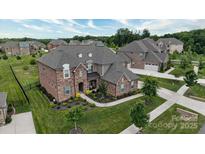 Stunning brick home featuring manicured landscaping, a stone facade, and a welcoming entrance at 12410 Franklin Park Ln, Huntersville, NC 28078