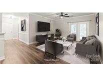 Staged living room featuring contemporary furnishings, TV, ceiling fan and balcony doors at 16344 Redstone Mountain Ln, Charlotte, NC 28277