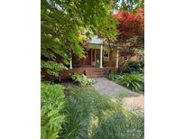 Inviting front porch with rocking chairs and lush landscaping at 19924 Floral Ln, Cornelius, NC 28031