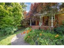 Charming brick home with a welcoming front porch, rocking chairs, and colorful landscaping at 19924 Floral Ln, Cornelius, NC 28031
