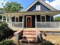Charming home featuring a front porch and a red front door, exuding curb appeal at 235 Jefferson E St, York, SC 29745