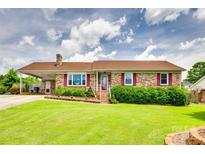 Charming brick home featuring a well-manicured lawn, red shutters, and a covered carport at 3903 Graywood Dr, Gastonia, NC 28052