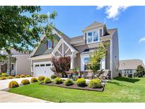 Charming two-story home featuring manicured landscaping, a two-car garage, and inviting front porch area at 5064 Lassen Volcanic Trl, Lancaster, SC 29720