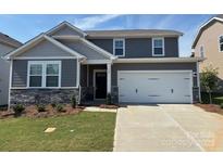 Charming two-story home featuring a two-car garage, stone accents, and well-maintained lawn at 565 Mountain View Dr, Monroe, NC 28110