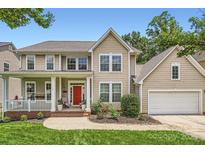 Charming two-story home with a red front door, inviting porch, attached garage, and well manicured landscaping at 5832 Lagrande Dr, Charlotte, NC 28269