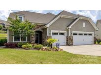 Charming home exterior boasts a well-manicured lawn, stone accents, and a two-car garage at 8035 Pastime Ln, Clover, SC 29710