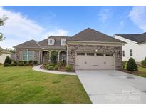Charming brick home featuring a two-car garage, well-manicured lawn, and inviting landscaping at 82120 Standing Oak Dr, Charlotte, NC 28278