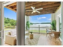 Inviting covered outdoor patio with wicker furniture offers scenic lake views and relaxing ambiance at 860 Jetton St # 59, Davidson, NC 28036