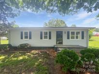 Charming single-story home with white siding, black shutters and front-yard landscaping at 908 Mccollough St, Statesville, NC 28677