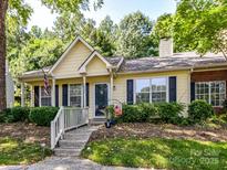 Charming yellow home with a cozy front porch and manicured landscaping at 9337 Four Mile Creek Rd # 101, Charlotte, NC 28277