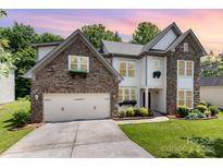 Two-story home features stone accents, attached garage, landscaped yard and a combination of vinyl and stone exterior at 10129 Loch Lomond Dr, Charlotte, NC 28278