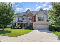 Charming two-story home boasts stone accents, red shutters, and a manicured lawn at 10203 Loch Lomond Dr, Charlotte, NC 28278