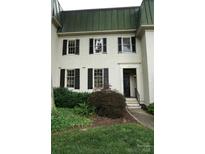 Charming exterior featuring a symmetrical facade, black shutters, and lush landscaping at 153 Perrin Pl, Charlotte, NC 28207