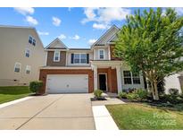 Charming two-story home featuring a brick facade, two-car garage, and well-maintained landscaping at 1569 Shannon Falls Dr, Fort Mill, SC 29715