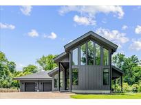 Stunning modern home showcasing expansive windows and dark siding, set against a backdrop of lush greenery at 3304 Mar Vista Cir, Charlotte, NC 28209