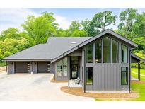 Contemporary home showcasing large windows, gray siding, and a spacious three-car garage at 3304 Mar Vista Cir, Charlotte, NC 28209