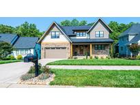 Beautiful two-story home showcasing stone accents, manicured lawn and an attached two car garage at 3741 9Th Street Ne Ct, Hickory, NC 28601