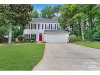 Charming two-story home with a well-manicured lawn, red door, and attached two car garage at 4000 Garfield Ct, Waxhaw, NC 28173