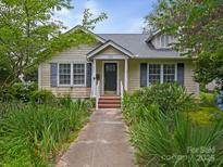 Charming home featuring a landscaped front yard and inviting entrance with dark shutters at 412 Dale Ave, Gastonia, NC 28052