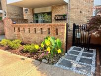 Charming patio entrance featuring beautiful flowerbeds, and modern gray pavers flanked by white gravel at 4736 Hedgemore Dr, Charlotte, NC 28209