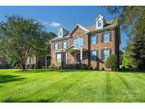 Beautiful brick two-story home with manicured lawn, dormer windows, and elegant entry at 512 Appomatox Dr, Marvin, NC 28173