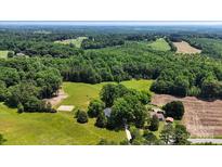 Expansive aerial view of a property featuring lush green fields and dense woodlands at 5740 Crouse Rd, Crouse, NC 28033