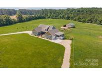 Sprawling home on a large lot, featuring a long drive, expansive lawn and mature trees at 830 John Rainey Rd, Salisbury, NC 28147