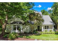 Charming home with a well-manicured lawn and inviting front porch nestled among mature trees at 833 Lemond Ln, Denver, NC 28037
