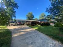 Charming single-story home with a long driveway and a well-maintained lawn under a clear blue sky at 903 Woodside Dr, Kings Mountain, NC 28086